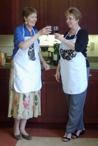 women clinking glasses wearing aprons
